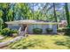 Charming single-story home features a gray brick exterior, green lawn and a red front door at 2755 Rockcliff Se Rd, Atlanta, GA 30316