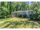 Charming single-story home features a gray brick exterior, green lawn and mature trees at 2755 Rockcliff Se Rd, Atlanta, GA 30316