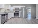 Modern kitchen featuring stainless steel appliances, white cabinets and gray laminate floors at 2755 Rockcliff Se Rd, Atlanta, GA 30316