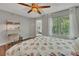 Cozy bedroom features a ceiling fan, a workspace with shelving, and a window with natural light at 301 Mill Pond Se Ct, Smyrna, GA 30082