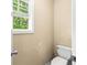 Compact powder room with a standard toilet and a window view at 531 Chadborn Ct, Lawrenceville, GA 30045