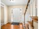 Welcoming foyer with wood floors, adjacent carpeted stairs, and white paneled wainscoting at 531 Chadborn Ct, Lawrenceville, GA 30045