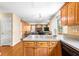 Kitchen with warm wood cabinets and view to the living room with fireplace at 531 Chadborn Ct, Lawrenceville, GA 30045