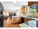 View of the kitchen showcasing hardwood floors, wooden cabinets, and black appliances, with open access to the living room at 531 Chadborn Ct, Lawrenceville, GA 30045