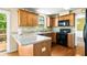 Well-lit kitchen with wood cabinets, black appliances, and bar-top counter; door to the backyard at 531 Chadborn Ct, Lawrenceville, GA 30045