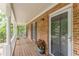 Covered brick front porch with wood floor and white columns at 4314 Arbor Bridge Ct, Marietta, GA 30066