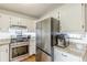 White kitchen with stainless steel appliances, granite countertops, custom cabinets and hardwood floors at 4314 Arbor Bridge Ct, Marietta, GA 30066