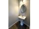 Cozy half-bathroom with pedestal sink and oval mirror at 5726 Silver Lake Dr, Mableton, GA 30126