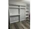 Bedroom with built in storage racks and shelves in the wall, and grey plank flooring at 6325 Stablewood Way, Lithonia, GA 30058