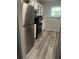 This kitchen features updated appliances, grey plank flooring, white cabinets, and a bright window at 6325 Stablewood Way, Lithonia, GA 30058