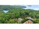 Aerial view of the property surrounded by lush greenery with Lake Lanier in the background at 7540 Shadburn Ferry Rd, Cumming, GA 30041