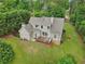 Aerial view of home showcasing the deck, large yard, and wooded surroundings at 7540 Shadburn Ferry Rd, Cumming, GA 30041
