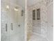 Elegant bathroom with glass shower, hexagon tile accent, and wallpapered linen storage at 7540 Shadburn Ferry Rd, Cumming, GA 30041