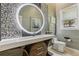 Stylish bathroom with a unique stone wall, modern vanity, a circular mirror with accent lighting, and elegant fixtures at 7540 Shadburn Ferry Rd, Cumming, GA 30041