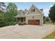 Craftsman style home boasts a large driveway, a two-car garage and a covered porch with an iron railing at 7540 Shadburn Ferry Rd, Cumming, GA 30041
