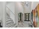 Bright foyer with staircase and modern art, offering a warm welcome at 7540 Shadburn Ferry Rd, Cumming, GA 30041