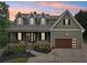 Charming two-story home with a covered front porch, landscaped yard, and attached garage at 7540 Shadburn Ferry Rd, Cumming, GA 30041