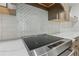 Modern kitchen features stainless steel cooktop with decorative tile backsplash at 7540 Shadburn Ferry Rd, Cumming, GA 30041