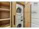 Laundry closet with stacked washer and dryer and wood cabinets at 7540 Shadburn Ferry Rd, Cumming, GA 30041