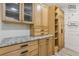 Laundry room with wood cabinets, granite countertop, and stacked washer/dryer at 7540 Shadburn Ferry Rd, Cumming, GA 30041