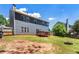 The backyard offers a wooden deck, fire pit, partial privacy fence and a two-story home with gray siding at 209 Courtland Oaks Sw Dr, Marietta, GA 30060