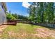 Expansive backyard featuring a wooden deck, fire pit, and privacy fence surrounded by mature trees at 209 Courtland Oaks Sw Dr, Marietta, GA 30060