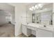 Bright bathroom featuring double sinks, a large mirror with vanity lighting, and a view into the adjoining bedroom at 209 Courtland Oaks Sw Dr, Marietta, GA 30060