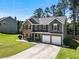 Beautiful two-story home features a brick and gray facade with black shutters and a two-car garage at 209 Courtland Oaks Sw Dr, Marietta, GA 30060