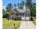 Charming two-story home features a brick and gray facade, well-manicured lawn, and a two-car garage at 209 Courtland Oaks Sw Dr, Marietta, GA 30060