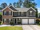 Beautiful two-story home features a brick and gray facade with black shutters and a two-car garage at 209 Courtland Oaks Sw Dr, Marietta, GA 30060