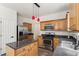 Kitchen featuring stainless steel appliances, laminate floors, and an island with stone countertops at 209 Courtland Oaks Sw Dr, Marietta, GA 30060