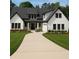 Beautifully landscaped home featuring a bright yard, dark framed windows, double-door entry, and neutral-toned driveway at 101 Deer Canyon Dr, Auburn, GA 30011