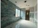 Beautiful shower with blue-green accent tiles, window, and built-in shelving, creating a spa-like experience at 101 Deer Canyon Dr, Auburn, GA 30011