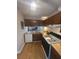 Compact kitchen with wooden cabinets, updated appliances, and a breakfast bar at 3414 Bayshore Dr, Atlanta, GA 30340