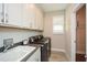 Laundry room with sink, plenty of storage cabinets, and washer/dryer machines at 422 Laurel Spring Ct, Canton, GA 30114
