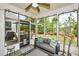Enclosed sunroom with a ceiling fan, stylish furniture, and views of the outdoor patio at 422 Laurel Spring Ct, Canton, GA 30114