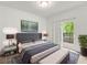 Comfortable bedroom with a large bed, a soft rug, a door to the balcony, and modern nightstands at 525 Parkway Ne Dr # 110, Atlanta, GA 30354