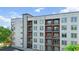 Modern apartment building with multiple floors, balconies, and large windows, situated beneath a blue sky with scattered clouds at 525 Parkway Ne Dr # 110, Atlanta, GA 30354