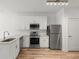 Kitchen features stainless steel appliances, including a dishwasher and range, paired with sleek white cabinetry and stone countertops at 525 Parkway Ne Dr # 110, Atlanta, GA 30354