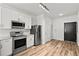 Modern kitchen boasts stainless steel appliances, white cabinets, stone counters, subway tile backsplash, and wood-look flooring at 525 Parkway Ne Dr # 110, Atlanta, GA 30354