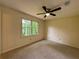 Bright carpeted bedroom featuring a ceiling fan and a window with views of mature trees at 5307 Red Rock Trce, Powder Springs, GA 30127
