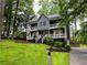 Charming two-story home with a double-decker porch surrounded by lush landscaping and tall trees at 5307 Red Rock Trce, Powder Springs, GA 30127