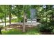 View of the rear of a home with a 2-car garage and wooden deck, surrounded by mature trees at 5307 Red Rock Trce, Powder Springs, GA 30127