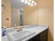 Close-up of the bathroom vanity with white countertop, dark cabinets and brushed gold fixtures at 1312 Pine Heights Ne Dr, Atlanta, GA 30324