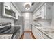 Modern kitchen with stainless steel appliances, white cabinetry, and granite countertops at 1312 Pine Heights Ne Dr, Atlanta, GA 30324