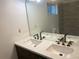 Bathroom featuring double sinks with modern faucets, quartz countertops, and a large mirror at 1754 Soapstone Ct, Decatur, GA 30034