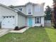 Charming home featuring a well-manicured lawn, garden beds, and a bright blue front door at 1754 Soapstone Ct, Decatur, GA 30034