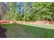Expansive backyard view with manicured lawn, mature trees, and a safety fence at 3352 Landings South Dr, Atlanta, GA 30331