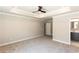 Spacious main bedroom with neutral carpeting, tray ceiling, and fan at 3352 Landings South Dr, Atlanta, GA 30331