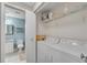 A laundry room features a washer and dryer with shelving and a view of a half bathroom with modern fixtures at 3655 Habersham Ne Rd # 244B, Atlanta, GA 30305